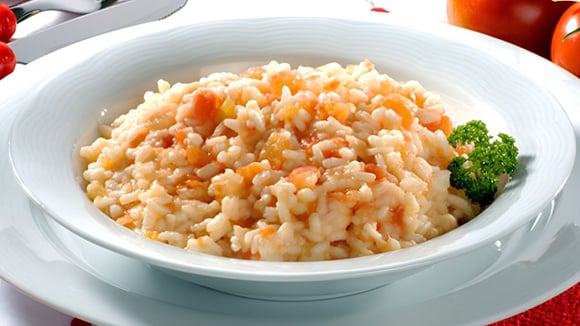 Risoto de tomate com pedaços do vegetal cheio de sabor em prato branco (Créditos: TudoGostoso)