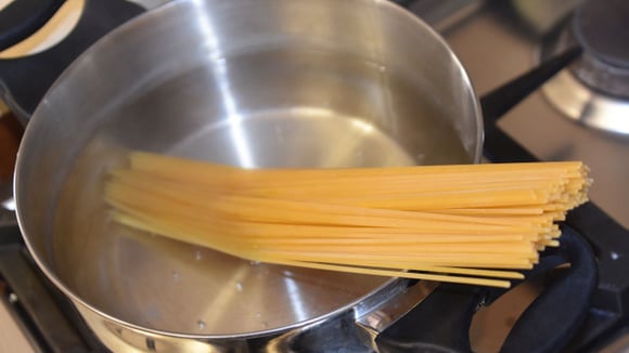 Macarrão sendo cozido em água e vinagre (Créditos: Canva)