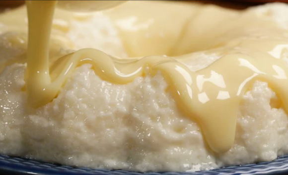 Cuscuz doce servido com fios generosos de leite condensado e coco ralado por cima. (Foto: TudoGostoso)
