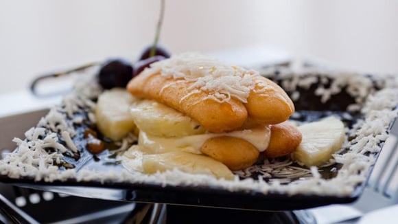 Fatia de torta de abacaxi saborosa com coco ralado por cima (Créditos: TudoGostoso)