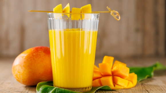 Suco de manga natural e refrescante decorado com palito com fatias da fruta (Créditos: Shutterstock)