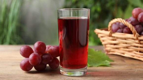 Suco de uva delicioso com cachos da fruta ao lado (Créditos: Shutterstock)