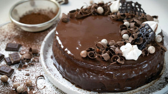 Torta de chocolate coberta por creme de chocolate e com decorações no topo (Créditos: Shutterstock)