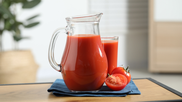 Jarra de suco de tomate saboroso com copo de suco atrás (Créditos: Shutterstock)