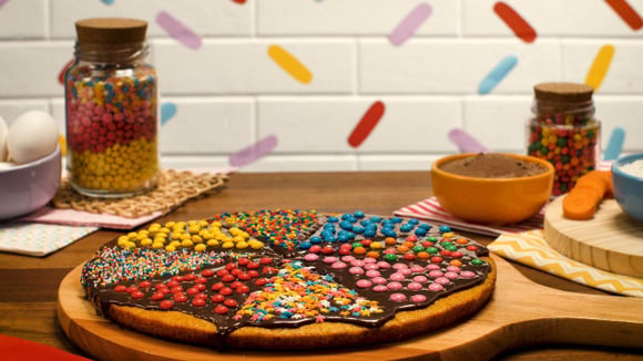 A base da pizza é feita com a massa do bolo de cenoura e a cobertura é um brigadeiro cremoso irresistível (Créditos: TudoGostoso)