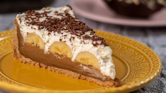 Fatia de torta de banana banoffee finalizada com raspas de chocolate em prato decorado (Créditos: TudoGostoso)