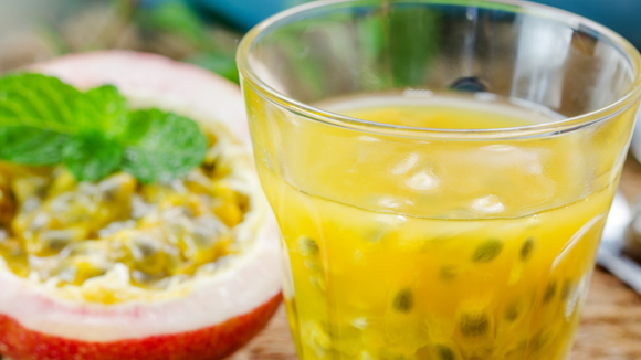 Suco de maracujá com sementes da fruta em copo de vidro (Créditos: Shutterstock)