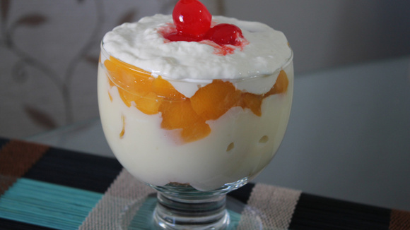 Pavê com fruta recheada com pêssegos finalizado com chantilly e cerejas em calda (Créditos: TudoGostoso)