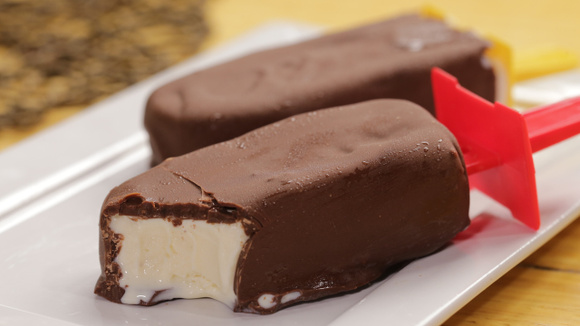 Picolé de leite em pó e chocolate em travessa com pedaço mordido (Créditos: TudoGostoso)
