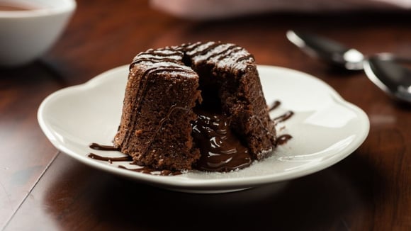 Petit gateau com calda de chocolate aberto e recheio escorrendo (Créditos: Shutterstock)