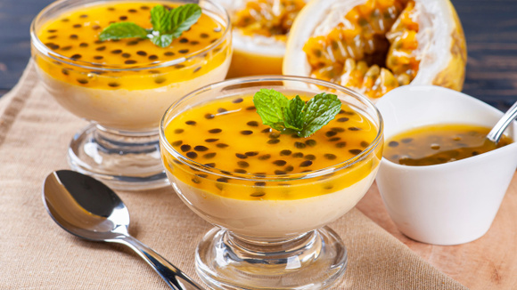 Mousse de maracujá finalizada com calda de maracujá com sementes e decorado com folha de hortelã (Créditos: TudoGostoso)