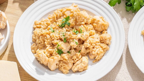 Risoto fácil cremoso finalizado com pimenta-do-reino e cebolinha acompanhado com frango em cubos (Créditos: Shutterstock)