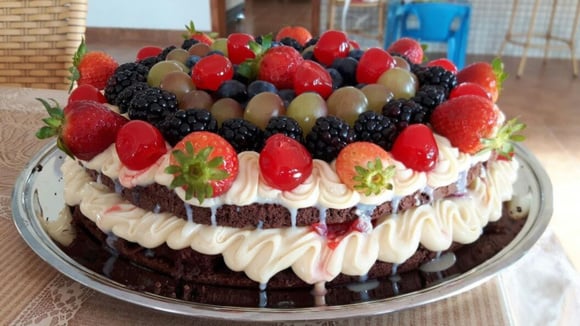 Naked cake de chocolate com brigadeiro branco e frutas vermelhas servido em prato (Créditos: TudoGostoso/Junior Crivelli)