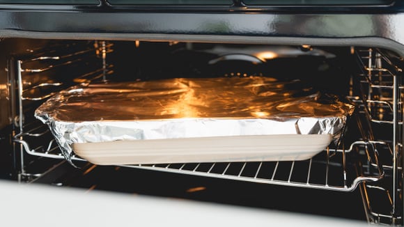 Preparo de receita no forno utilizando folha de alumínio para reter o calor. (Foto: Shutterstock)