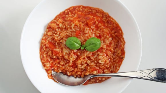Depois de pronto, finalize o risoto com tomates frescos, folhas de manjericão e bastante queijo (Créditos: Shutterstock)