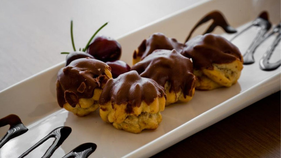 Porções de carolinas ou bombas com cobertura de chocolate de sobras de ovo de Páscoa derretido (Créditos: TudoGostoso)