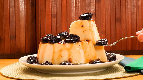  
Pedaços de manjar de coco com calda de ameixa deliciosa servidos em prato (Créditos: TudoGostoso)