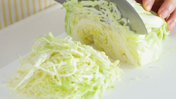 Repolho verde sendo picado (Créditos: Canva)