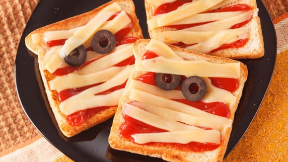 Mini pizza de múmia para o Halloween com molho de tomate, tiras de queijo mussarela e rodelas de azeitona (Créditos: Shutterstock)