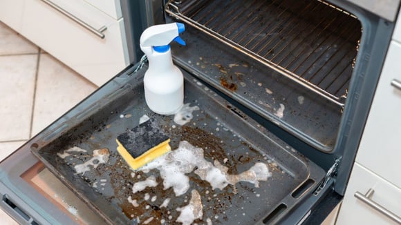 Remover os respingos após cada uso e cobrir os alimentos com papel-alumínio ajuda a evitar a formação de crostas de sujeira no forno (Créditos: Shutterstock)