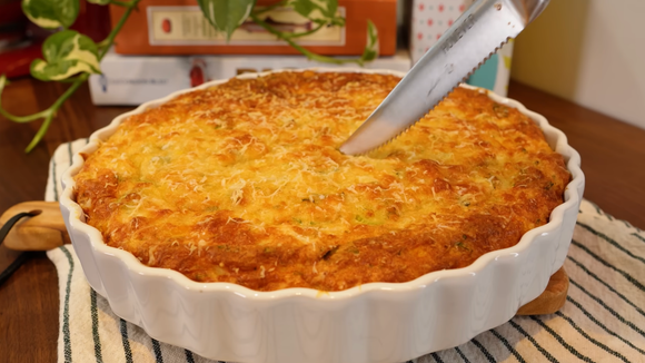 Torta salgada assada em refratário cerâmico com cobertura de queijo perfeitamente gratinado. (Foto: reprodução Ana Zambrin no Youtube)