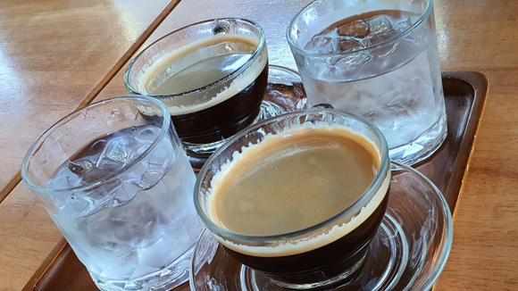 Os baristas balançam a cabeça quando veem um copo de água junto com o café expresso. Quase todo mundo erra ao bebê-lo