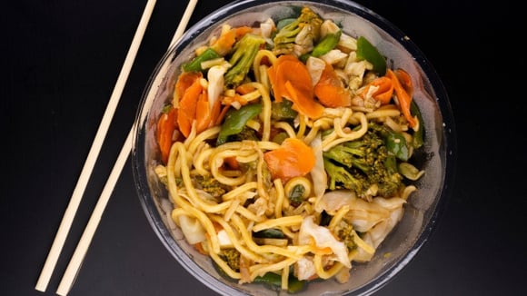 Yakisoba gelado com cenoura, brócolis, pimentão, entre outros, em tigela com hashi (Créditos: Shutterstock)