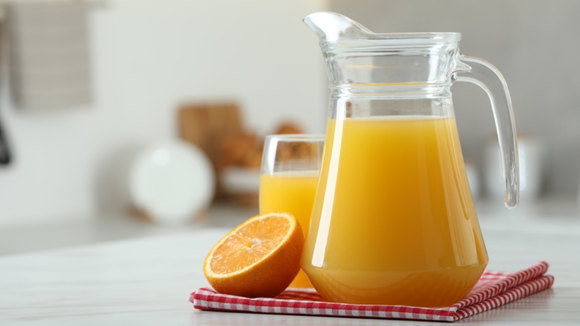 Jarra com suco de laranja fresquinho e maravilhoso com copo de suco atrás (Créditos: Shutterstock)