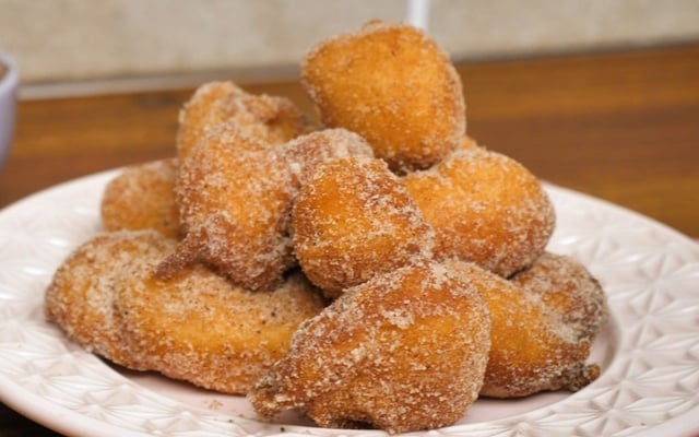 Porção de bolinho de chuva com canela e açúcar no prato