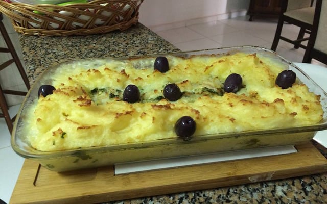 Bacalhau à Zé do Pipo com azeitonas em uma travessa