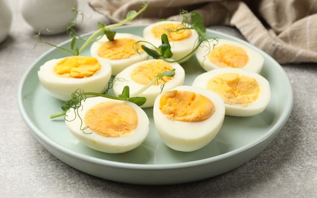 Ovo cozido na airfryer cortados ao meio com ervas frescas no prato