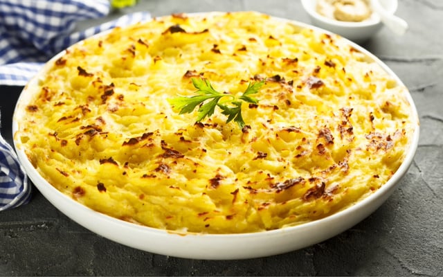 Bacalhau com natas gratinado em uma prato redondo grande