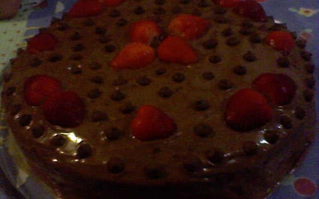 Bolo de chocolate com recheio de flocos e creme com morangos