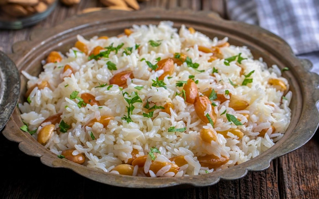 Arroz com amêndoas laminadas e temperos na travessa de metal