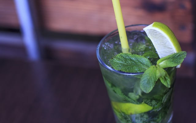 Mojito tradicional com rum, limão e hortelã no copo com canudo