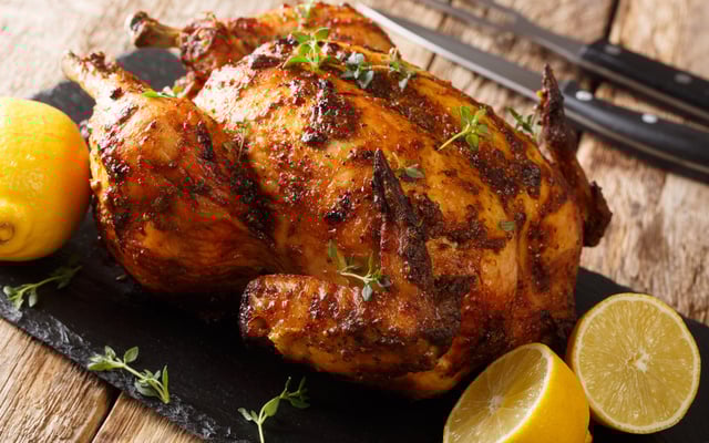 Frango assado recheado com farofa finalizado com ervas