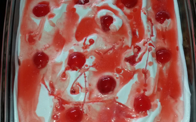 Pavê de chocolate coberto com chantilly e cerejas