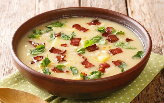 Sopa de mandioca com bacon finalizada com folhas