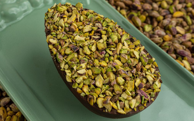 Ovo de Páscoa de pistache coberto com pedaços da oleaginosa