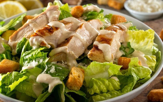 Salada caesar com alface, frango grelhado em tiras e molho caesar