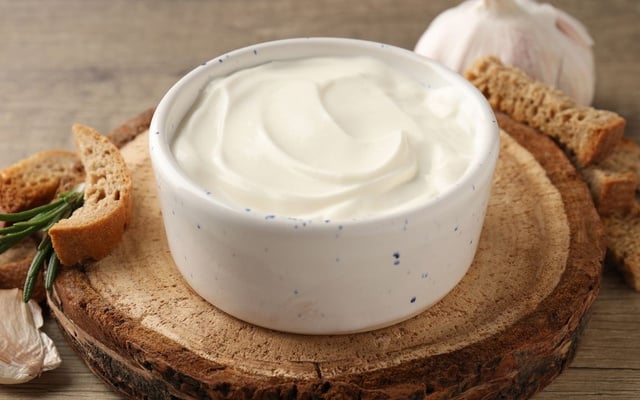 Creme de alho cremoso servido em recipiente com torradinhas