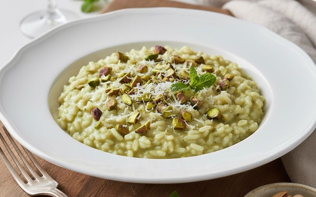 Risoto de pistache cremoso finalizado com queijo ralado