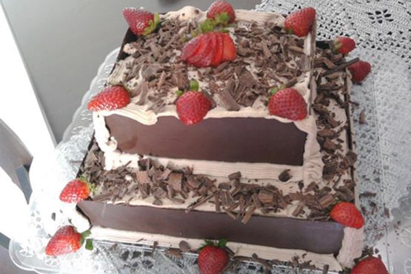 Bolo de chocolate com recheio de flocos e creme com morangos