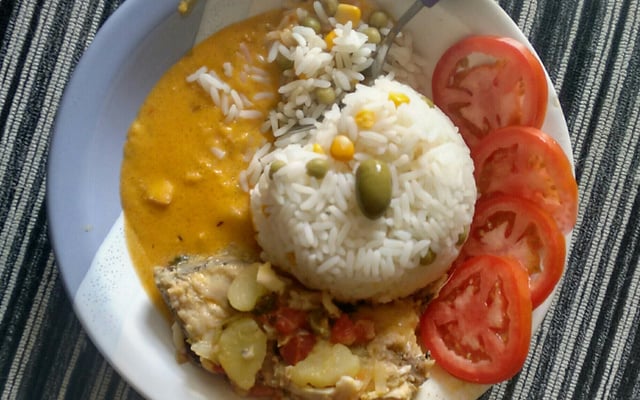 Peixe cozido servido com arroz branco e tomates