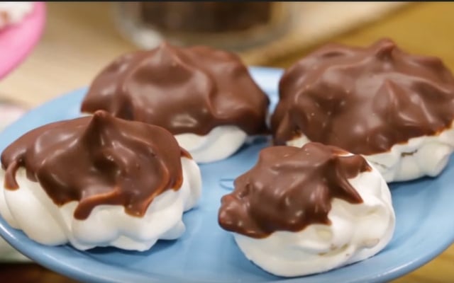 Porção de suspiro caseiro coberto com chocolate no prato azul