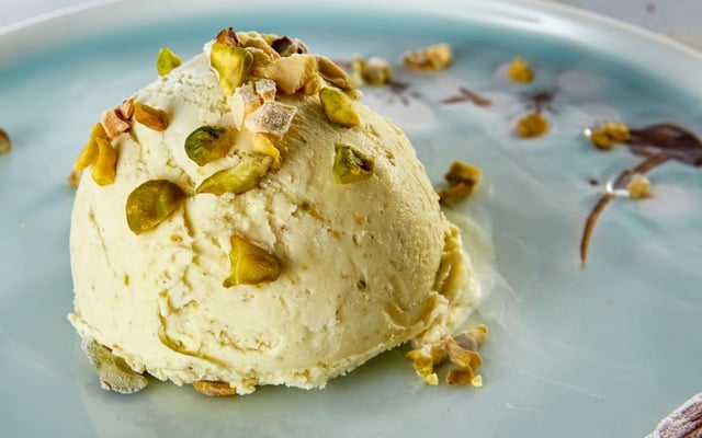 Sorvete de pistache cremoso finalizado com sementes picadas