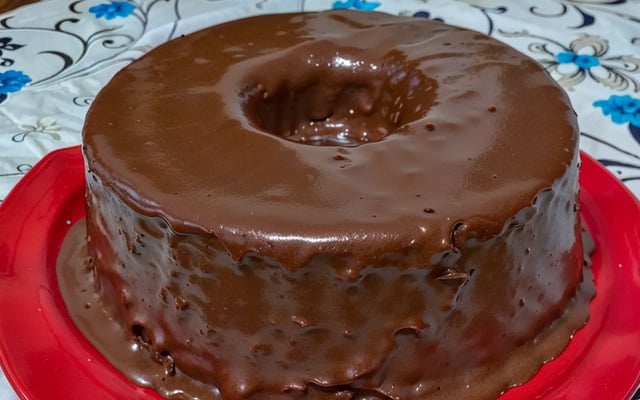 Bolo de chocolate redondo com calda escorrendo pelas laterais
