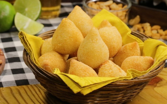 Porção de coxinha de frango dourada e sequinha servida na mesa
