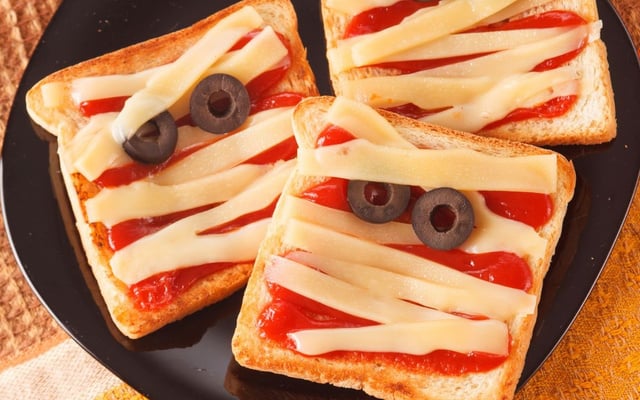 Mini pizza de múmia com queijo em tiras e azeitonas
