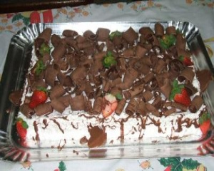 Bolo de chocolate com recheio de flocos e creme com morangos